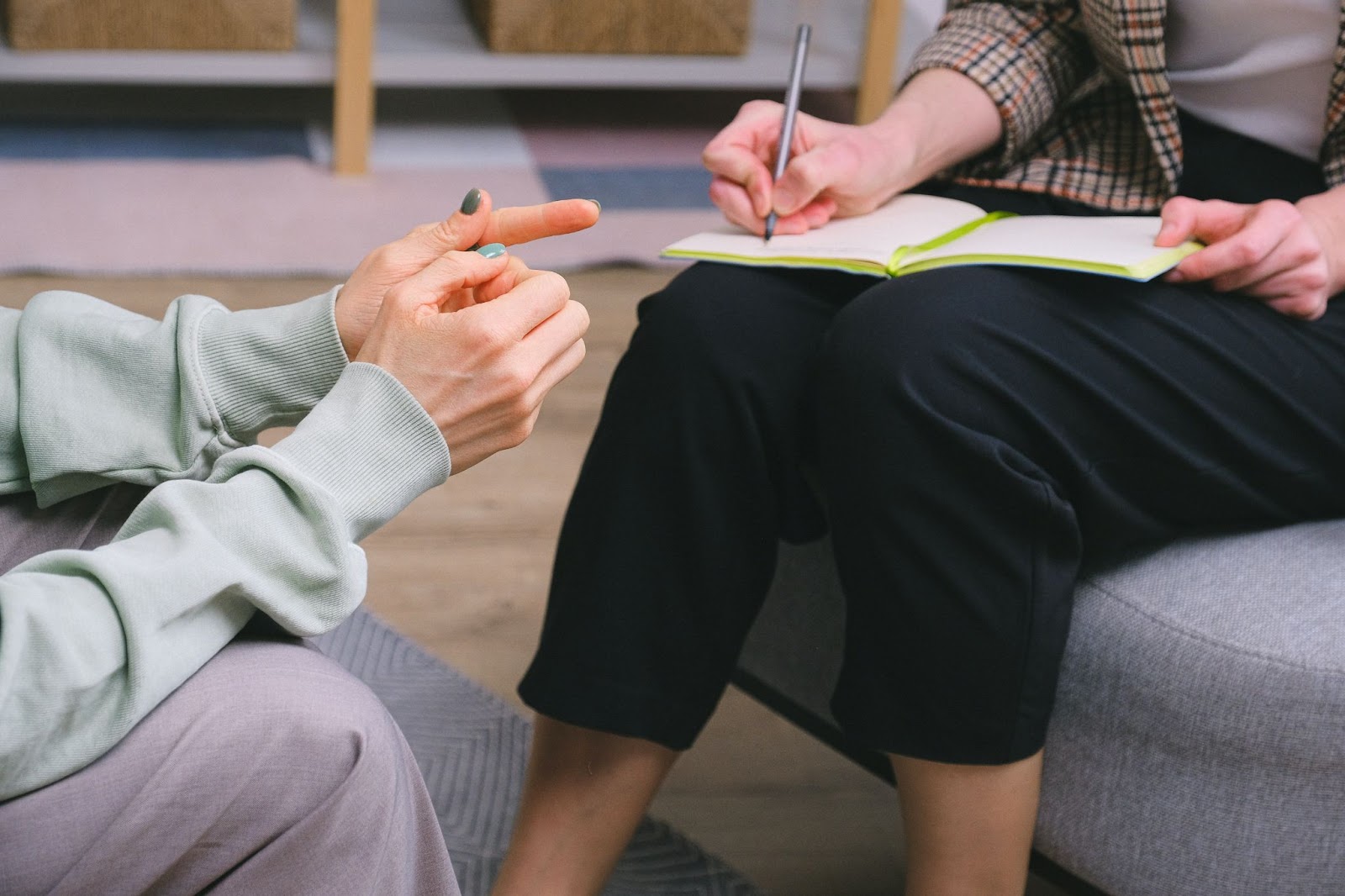 A doctor and his patient having a conversation while the doctor notes down the complaint in their journal