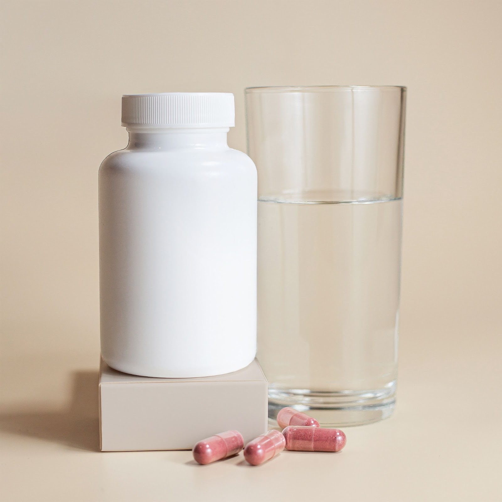 An NMN supplement bottle with a glass of water