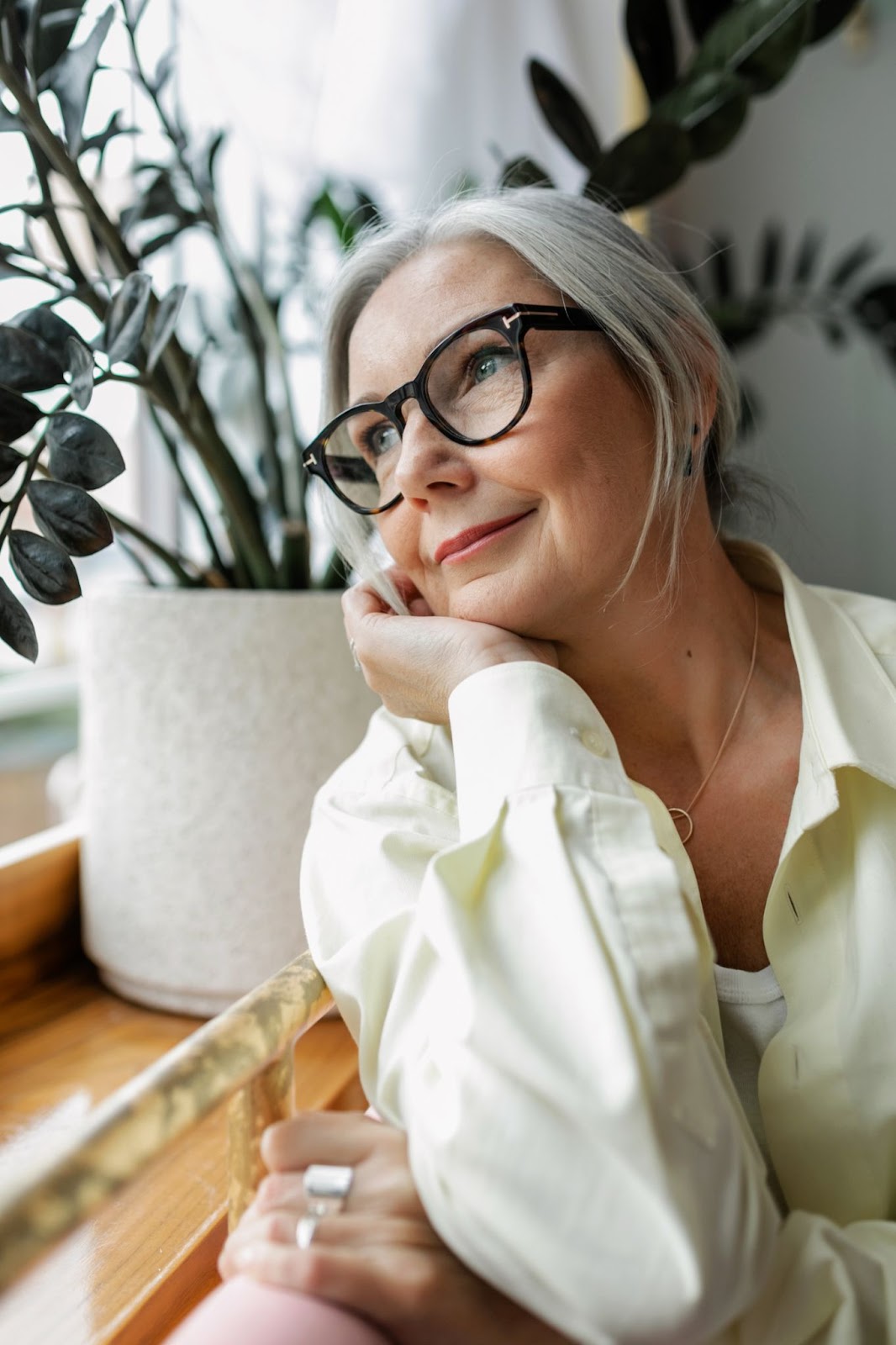 A woman wearing glasses with a glowing skin