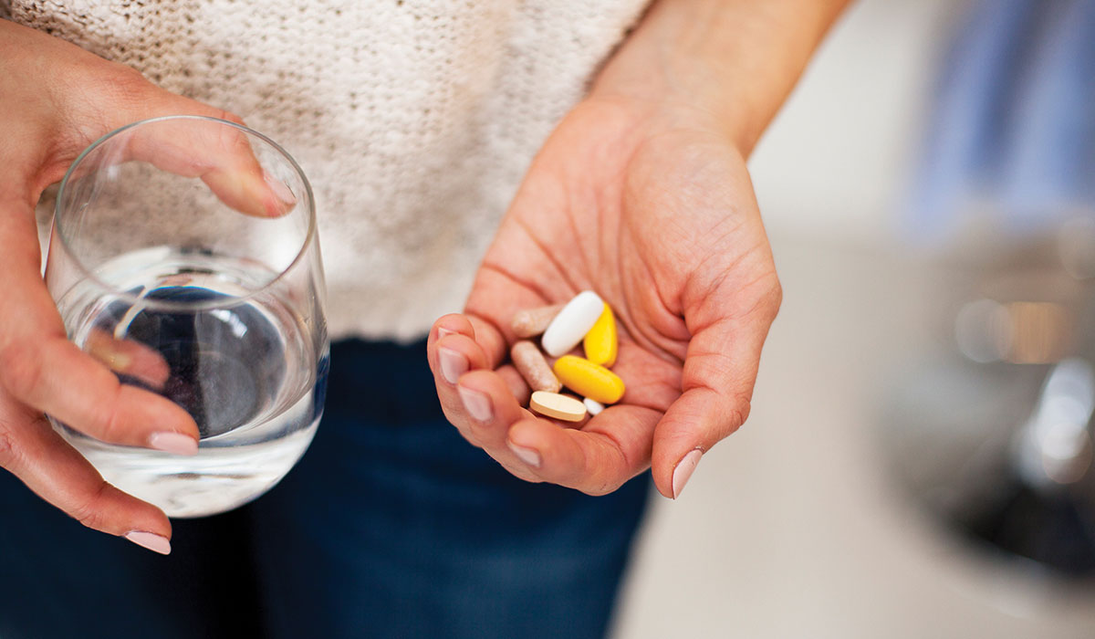 A handful of ashwagandha supplements with a glass of water