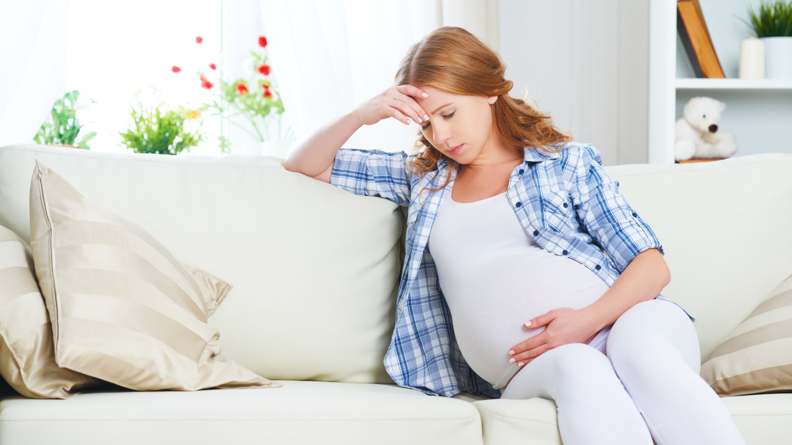 A pregnant woman sitting on a couch